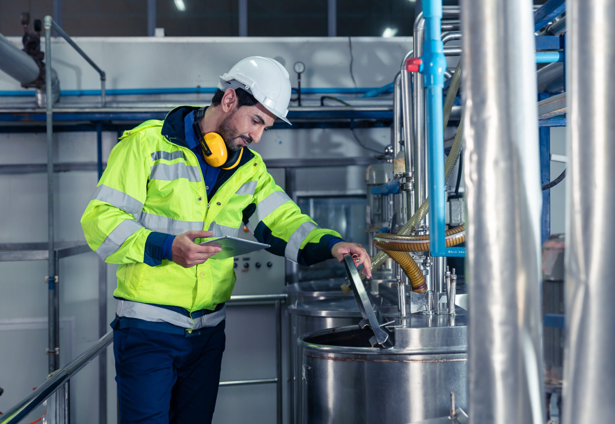 Industrial factory worker, Engineer staff working in food and drinks factory, Control check quality condition of liquid pipe supply in plant.