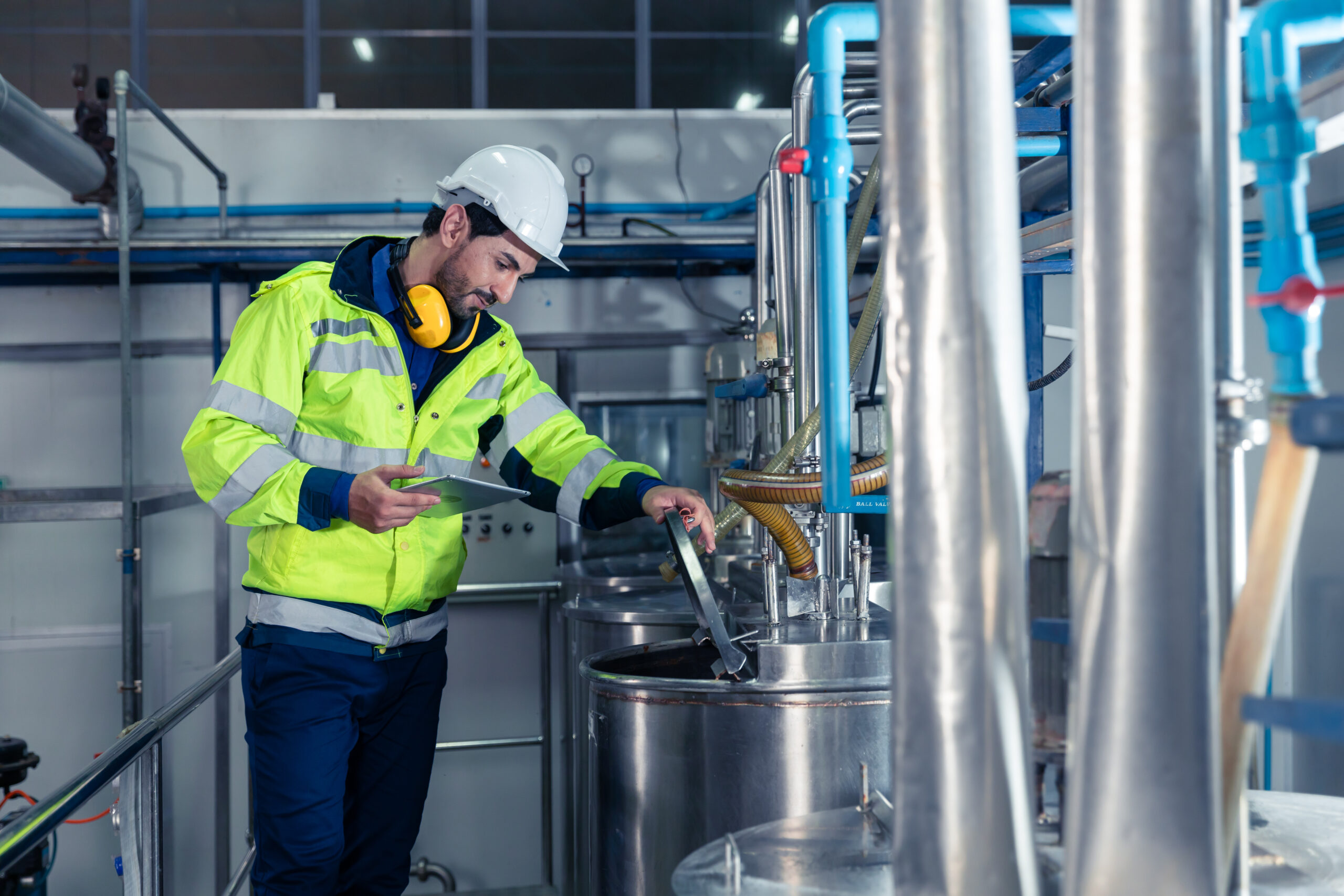 Industrial factory worker, Engineer staff working in food and drinks factory, Control check quality condition of liquid pipe supply in plant.